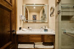 y baño con lavabo, espejo y ducha. en Kosh Havuz boutique hotel, en Samarkand