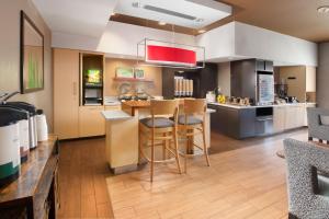 a large kitchen with a bar with stools in it at TownePlace Suites Fort Worth Southwest TCU Area in Fort Worth