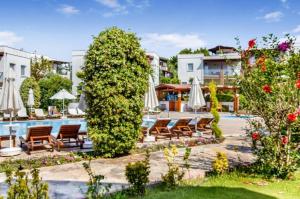 a resort with a pool and chairs and umbrellas at Dibek Homes Villa & Hotel in Yalıkavak
