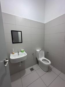 ein weißes Bad mit einem WC und einem Waschbecken in der Unterkunft 55 Cozy Home Mount Austin Eco Adda Setia Indah Daya in Johor Bahru