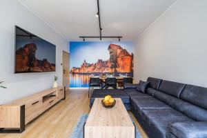 a living room with a couch and a table at Apartament Gdansk Stare Miasto in Gdańsk