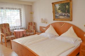 Hotel Harzer am Kurpark في باد هيرنالب: غرفة نوم بسرير مع صورة على الحائط