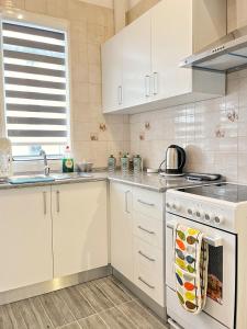 a kitchen with white cabinets and a stove top oven at Maria & Matthias - Apartments in Central of Floriana in Il-Furjana +53 photos