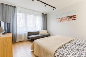 a bedroom with a bed and a chair and a television at Apartament Gdansk Stare Miasto in Gdańsk