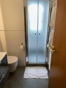 een badkamer met een toilet en een glazen douche bij Gasthaus Rogge in Lemgo