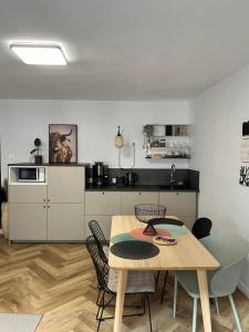 een keuken met een tafel en stoelen in een kamer bij AlmaOldTown - Centrum - Check-In 24h in Wrocław