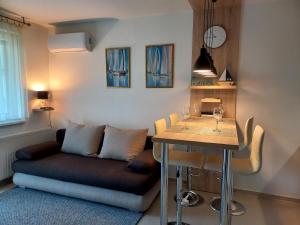 un salon avec un canapé et une table dans l'établissement Riviéra Wellness Apartman, à Siófok