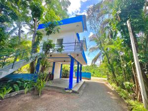 a blue and white house with a staircase outside at Jungle Fence in Bentota