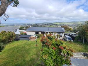 a house on top of a hill with a yard at Hilltop Blue Sky House in Porirua