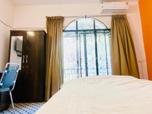 a bedroom with a bed and a window at Relaxing 4 Bedroom AC Near Pune Airport Free Wifi in Pune