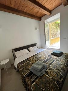 1 dormitorio con 1 cama grande y ventana en Charme in Centro with private parking, en Ascoli Piceno