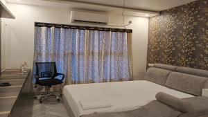 Atlantis Resort Spa Restaurant Swimming Pool, Banquet Hall, Guntur. في جونتور: غرفة نوم بها سرير وكرسي ونافذة