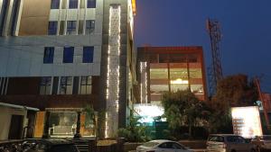 Atlantis Resort Spa Restaurant Swimming Pool, Banquet Hall, Guntur. في جونتور: مبنى مرتفع مع سيارات متوقفة أمامه