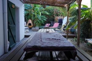 un patio con mesa y sillas en un porche en JOYU SURF SHACK, en Bidart