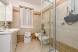 a bathroom with a toilet and a sink and a shower at Ciliegia in Tignale +42 photos