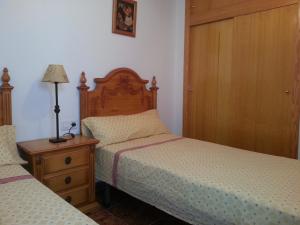 sypialnia z 2 łóżkami i komodą z lampką w obiekcie Residence Lucia B&B w mieście Guardamar del Segura