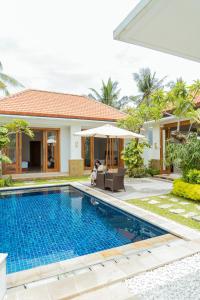 a villa with a swimming pool in front of a house at Villa Nugraha Lovina Private Pool in Singaraja