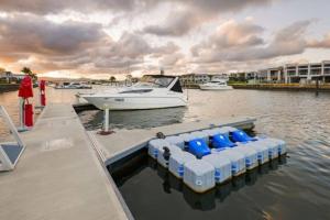 un quai avec des bateaux bleus et blancs dans l'eau dans l'établissement Hope Island Little Paradise, à Gold Coast