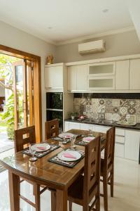 a kitchen with a wooden table with chairs and a tableablish at Villa Nugraha Lovina Private Pool in Singaraja