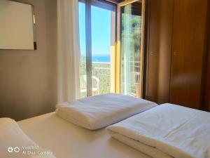 a bedroom with two beds and a large window at Hotel Garden in Torri del Benaco