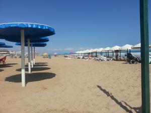 een strand met parasols en stoelen en de oceaan bij Residence Lucia B&B in Guardamar del Segura