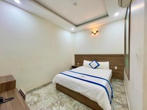 a hotel room with a bed and a desk at Khách Sạn TRẦN LONG in Ho Chi Minh City