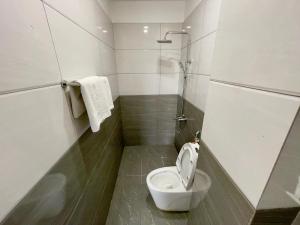 a small bathroom with a toilet and a shower at Khách Sạn TRẦN LONG in Ho Chi Minh City