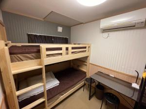 een kamer met een stapelbed en een bureau bij GuestHouse OC in Fujikawaguchiko