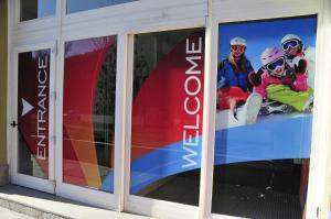 Un groupe de personnes est assis sur un écran de fenêtre dans l'établissement Villaggio Olimpico, à Bardonnèche