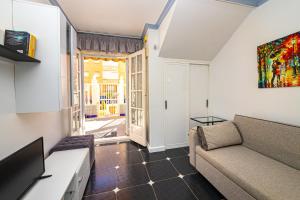 a living room with a couch and a tv at Puerto Romano 21 in La Mata