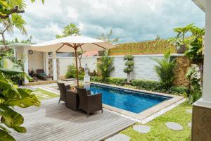 a backyard with a swimming pool and an umbrella at Villa Nugraha Lovina Private Pool in Singaraja