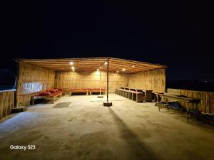 um grande edifício de madeira com mesas e bancos à noite em SYED Rest House em Karachi