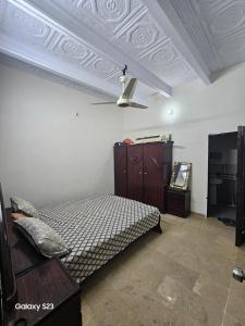 um quarto com uma cama, uma cómoda e um tecto em SYED Rest House em Karachi