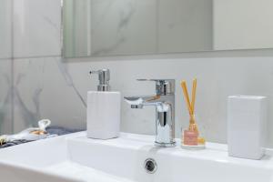 a bathroom sink with a faucet and a mirror at Magical Brand New Suite in Zipárion