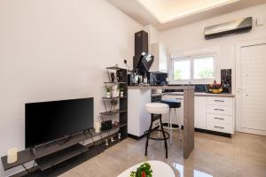 a kitchen with a flat screen tv and a counter at Magical Brand New Suite in Zipárion