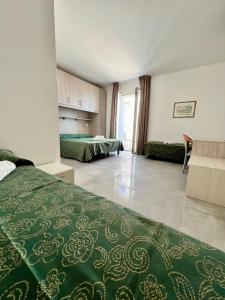 a hotel room with two beds and a living room at Hotel Terramare in Lido di Jesolo