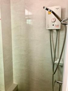 a shower in a bathroom with a machine on the wall at The Apartium - Modern Apartment Rentals in Bangkok