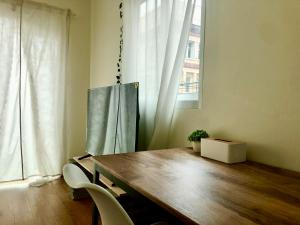 a dining room with a wooden table and chairs and a window at The Apartium - Modern Apartment Rentals in Bangkok