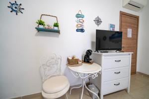 Habitación con TV, silla y mesa. en Il Poggetto di Porto Ercole, en Porto Ercole