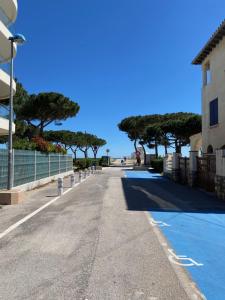 una calle vacía con árboles al lado de un edificio en Appartement neuf 4pers. 250 mètres de la plage, en Argelès-sur-Mer