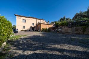 a large white house with a stone wall at Il Poggetto di Porto Ercole in Porto Ercole