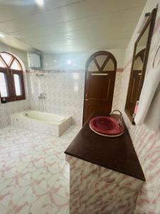 a bathroom with a bath tub and a red plate on a counter at Calm Cottage KASAULI HILLS Barog in Barog