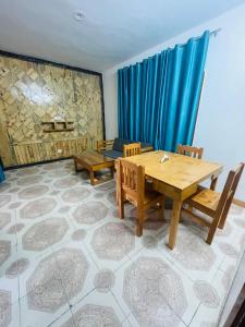a dining room with a wooden table and chairs at Calm Cottage KASAULI HILLS Barog in Barog