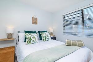 a bedroom with a large white bed with green pillows at Mountain View Villa in Cape Town