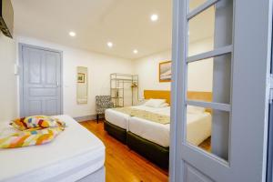 a bedroom with two beds and a sliding glass door at À Francos Painting Artist 2 in Porto