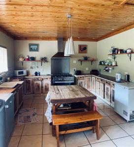 a kitchen with wooden cabinets and a wooden table at Up The Hill Guesthouse in Kestell