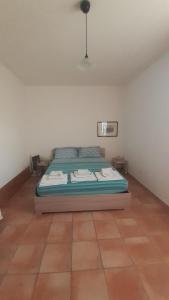 ein Schlafzimmer mit einem Bett in der Ecke eines Zimmers in der Unterkunft Isuedda in Marrùbiu