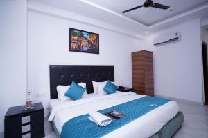 um quarto com uma cama grande e almofadas azuis em Hotel Moon Taj Near Yashobhoomi Convention Centre em Nova Deli
