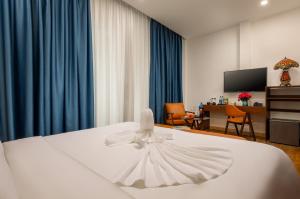 a hotel room with a white bed with a dress on it at Casa Valentina Hanoi Hotel in Hanoi
