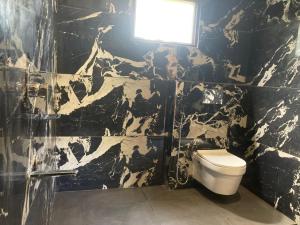 a black and white bathroom with a toilet and a light at Sattal Valley Resort in Bhīm Tāl